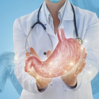 Doctor shows the stomach is drawn on a blue background.